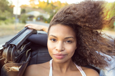 Portrait of smiling woman sitting in convertible car - CAVF01436