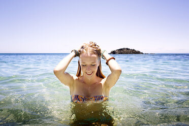 Mlata, Teenage girl wearing bikini, standing in the sea at Comino beach  stock photo