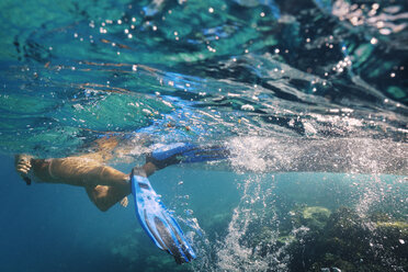 Frau mit Tauchflossen schwimmt unter Wasser - CAVF01492