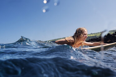 Woman surfboarding in sea against clear sky - CAVF01494