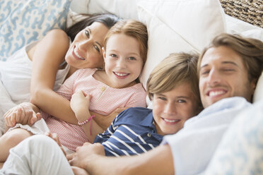 Family relaxing together on sofa - CAIF07932