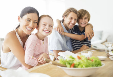 Die Familie sitzt zusammen am Tisch - CAIF07934