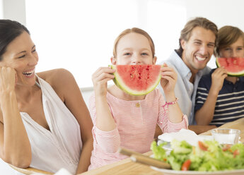 Familie isst Wassermelone am Tisch - CAIF07942