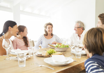 Mehrgenerationenfamilie beim gemeinsamen Essen am Tisch - CAIF07944
