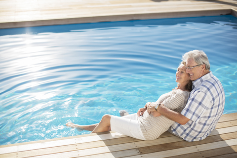 Älteres Paar entspannt am Pool, lizenzfreies Stockfoto