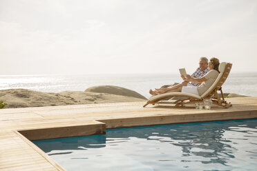 Älteres Paar entspannt am Pool - CAIF07947