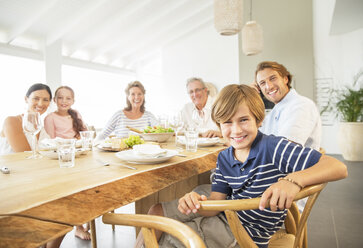 Family smiling together at table - CAIF07950