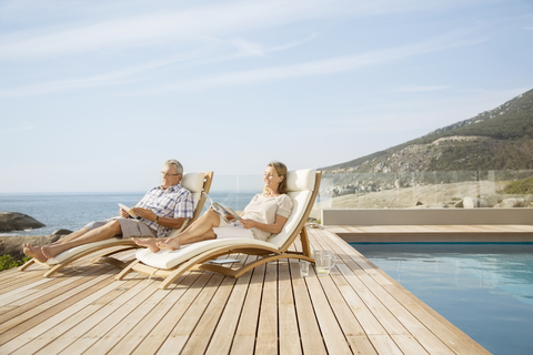 Älteres Paar entspannt am Pool, lizenzfreies Stockfoto