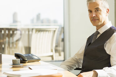 Businessman sitting at desk in office - CAIF08022