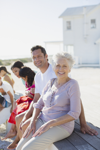 Mehrgenerationenfamilie lächelt vor dem Strandhaus, lizenzfreies Stockfoto