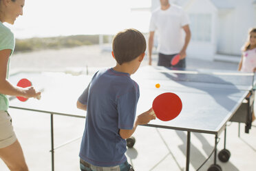 Familie spielt gemeinsam Tischtennis im Freien - CAIF08052