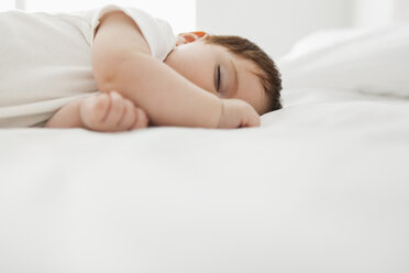 Baby girl sleeping on bed - CAIF08075