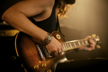 Mittelteil eines Mannes, der in einem Rockmusikstudio Gitarre übt - CAVF01587