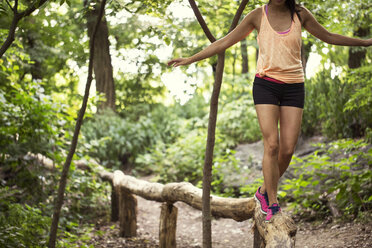 Low section of woman walking on railing at park - CAVF01610