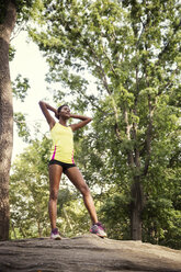 Woman exercising while standing on tree trunk - CAVF01611