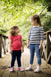 Girls talking while standing on footbridge - CAVF01680