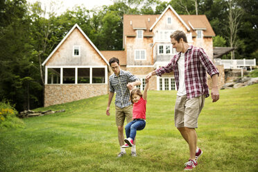 Men swinging girl in backyard - CAVF01682