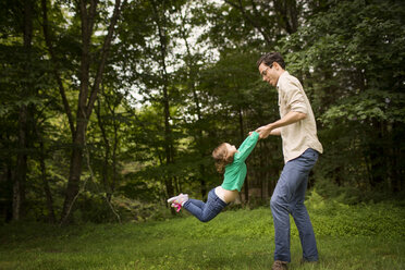 Seitenansicht eines Mannes, der mit seiner Tochter auf einem Feld spielt - CAVF01694