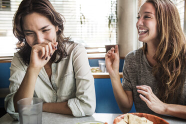 Glückliche Frauen sitzen im Restaurant - CAVF01702