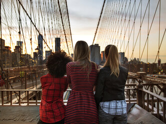 Rückansicht von Freunden, die am Geländer der Brooklyn Bridge stehen - CAVF01713