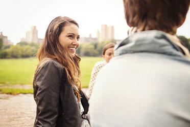 Lächelnde Frau sieht ihren Freund an, während sie im Central Park sitzt - CAVF01730