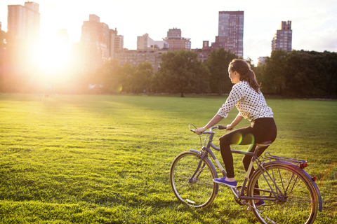 Seitenansicht Frau Radfahren im Central Park in der Stadt, lizenzfreies Stockfoto