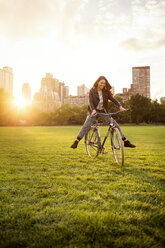 Playful woman cycling in Central Park - CAVF01741