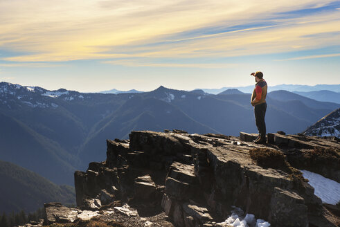 Seitenansicht eines auf einem Berg stehenden Mannes bei Sonnenuntergang - CAVF01789