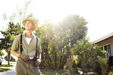 Gardener looking away while standing at backyard - CAVF01910