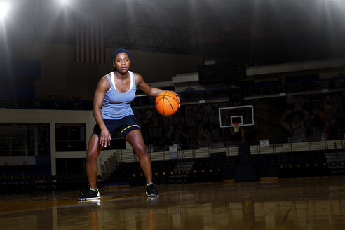 Porträt einer Frau, die auf dem Platz Basketball übt - CAVF01954