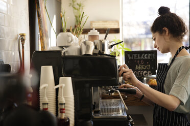 Woman making coffee in cafe - CAVF01984