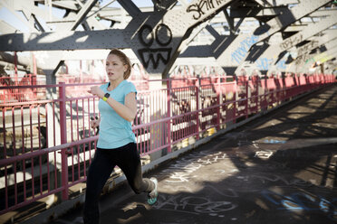 Weibliche Athletin läuft auf dem Fußgängerweg der Williamsburg Bridge - CAVF02027