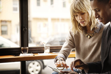 Friends using tablet computer while sitting in bar - CAVF02122