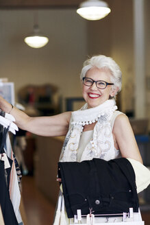 Porträt einer lächelnden Frau beim Einkaufen in einer Boutique - CAVF02156