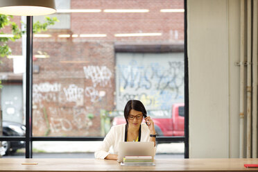 Geschäftsfrau arbeitet an einem Laptop im Büro - CAVF02187
