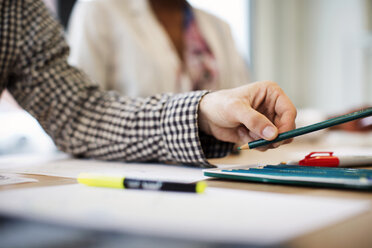 Abgeschnittenes Bild von Hand hält Bleistift bei der Arbeit im Büro - CAVF02199