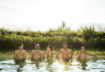 Happy friends enjoying in pool against clear sky - CAVF02298