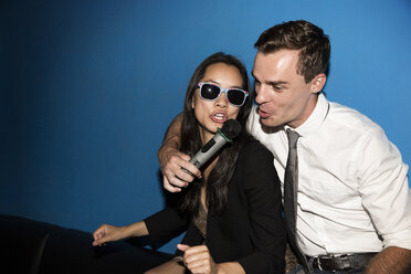 Glückliches Paar singt Karaoke in einem Nachtclub - CAVF02331