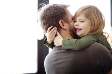 Glücklicher Vater umarmt seine Tochter zu Hause - CAVF02399