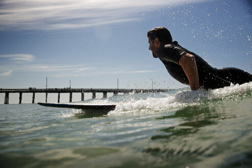 Seitenansicht eines Mannes beim Surfen im Meer gegen den Himmel - CAVF02647