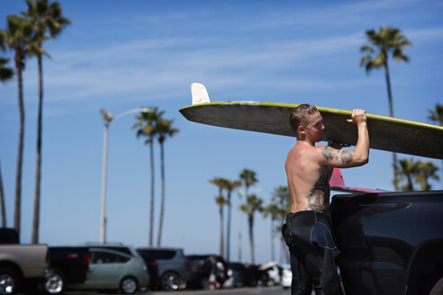 Seitenansicht eines Mannes mit Surfbrett am Strand - CAVF02650