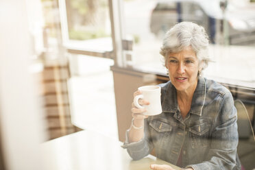 Frau schaut beim Kaffeetrinken im Café weg - CAVF02680