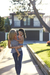 Mother carrying son while walking at backyard - CAVF02699