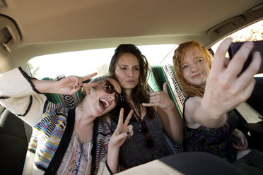 Happy friends taking selfie while sitting in car - CAVF02751