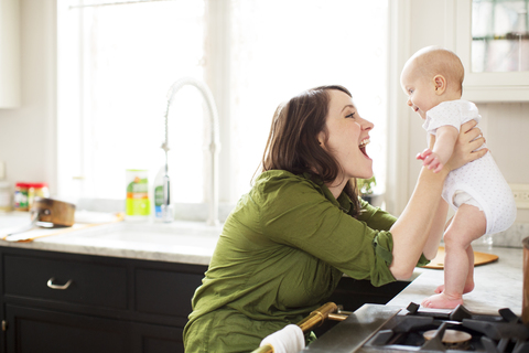 Happy mother playing with baby girl in bathroom stock photo