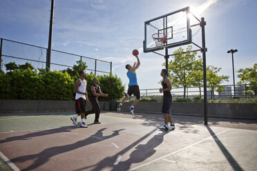 Freunde spielen Basketball im Hof an einem sonnigen Tag - CAVF03124