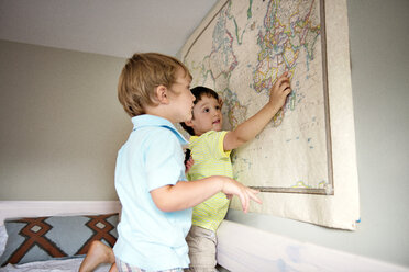 Siblings looking at map on wall - CAVF03216