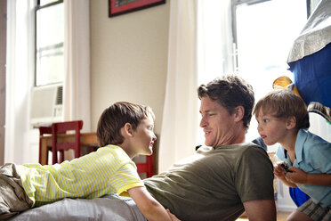 Glücklicher Vater entspannt sich mit seinen Söhnen zu Hause - CAVF03223