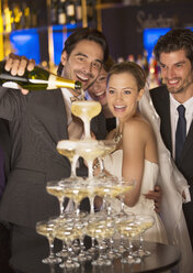Bräutigam gießt Champagner-Pyramide bei der Hochzeitsfeier - CAIF08150