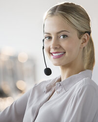 Businesswoman wearing headset in office - CAIF08168